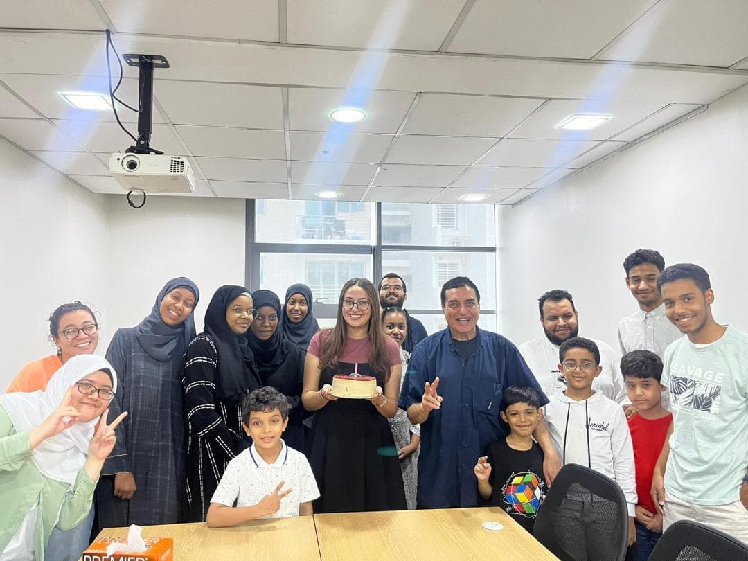 Students and staff celebrating with a birthday cake