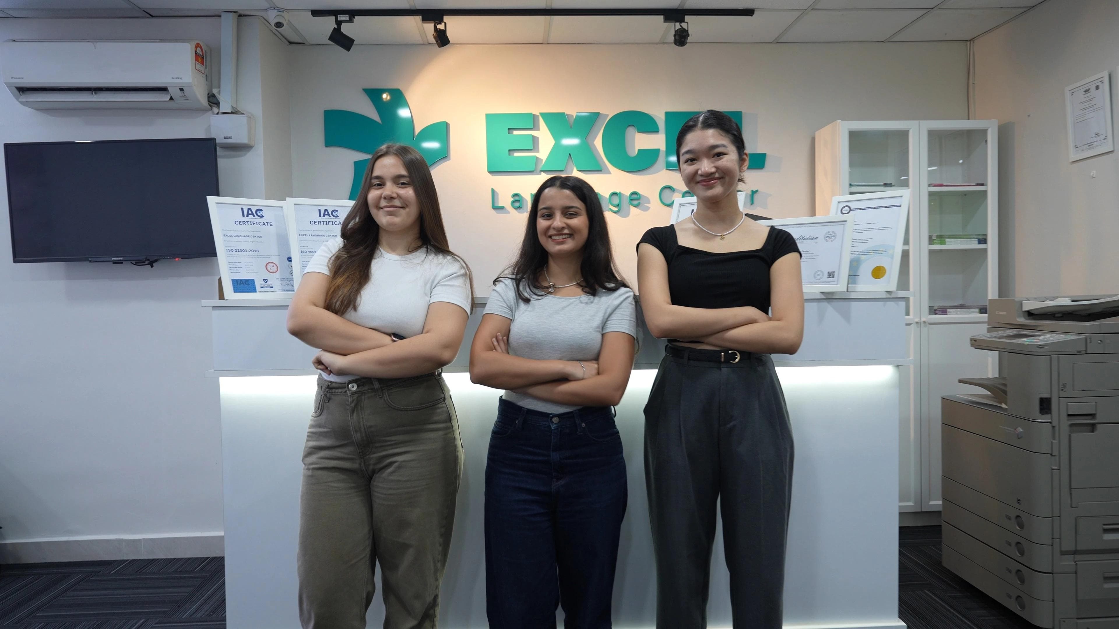 Three students posing at the reception desk