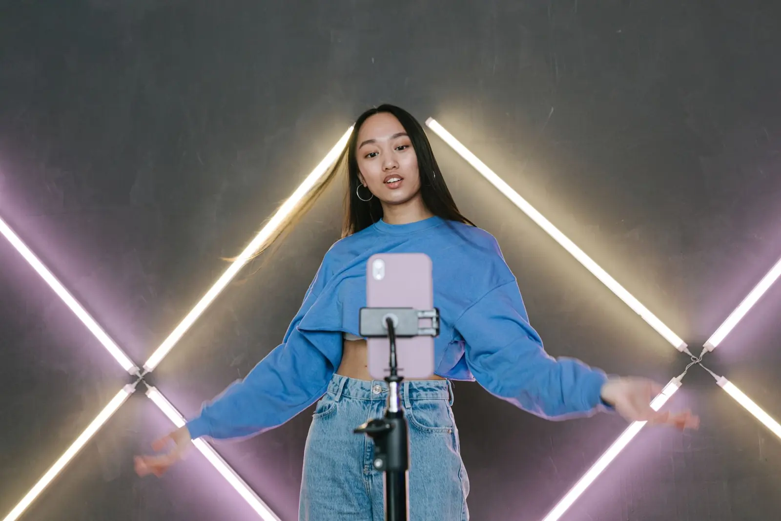 Young woman recording a video with her phone on a tripod