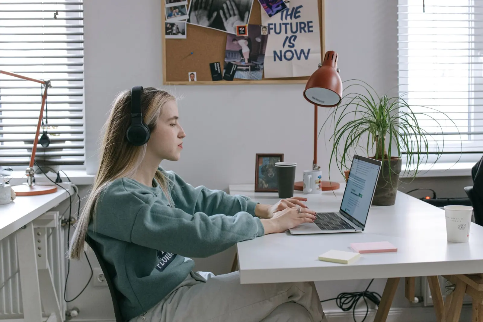 Young woman with headphones following an online lesson at her desk