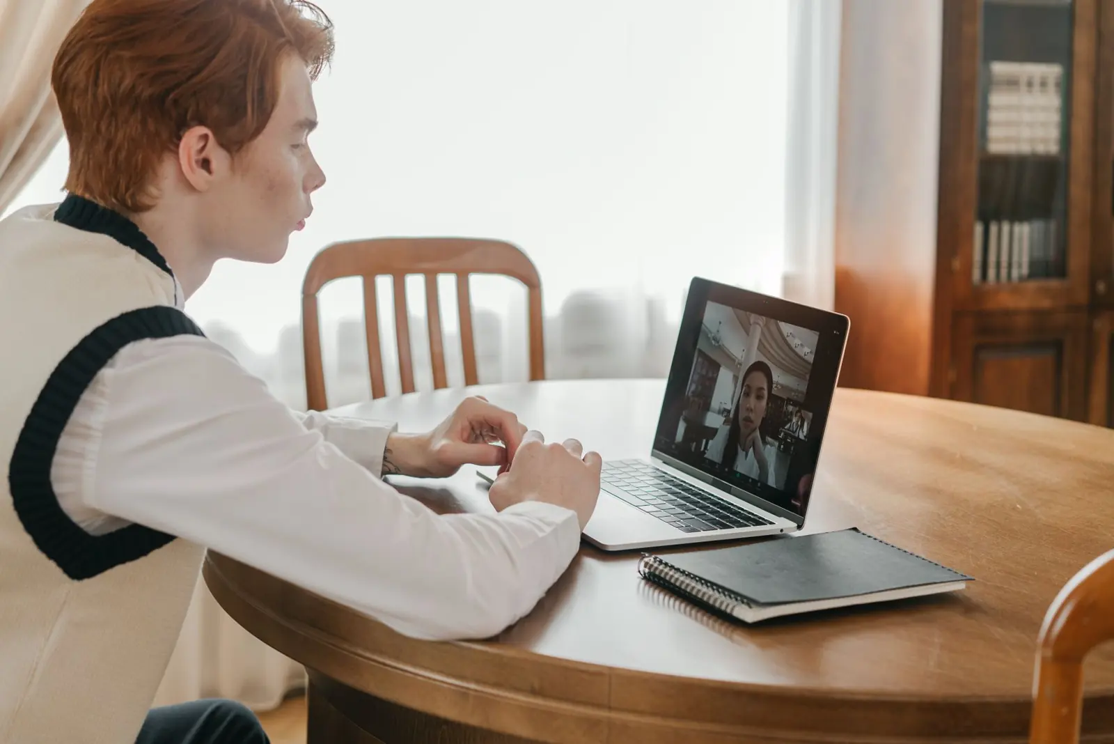 Young man in a video lesson with his teacher on a laptop