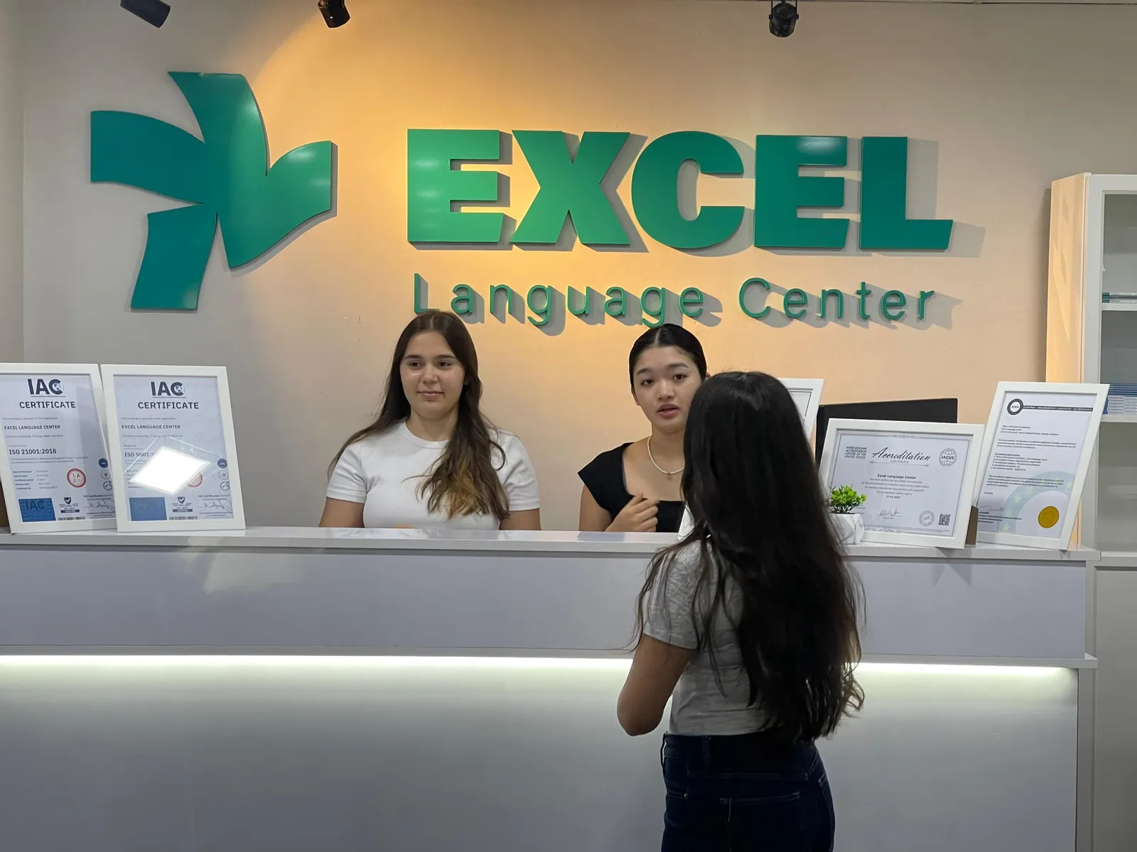 Students at the Excel Language Center reception desk